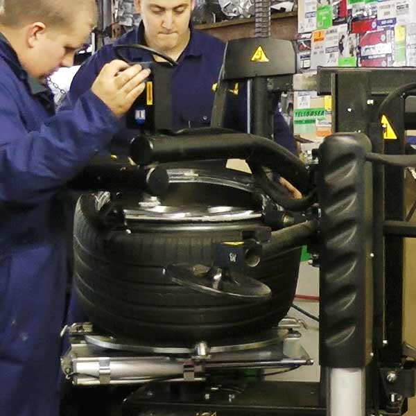 distance view of a new tyre being fitted by our tyre specialist using the lastest tyre fitting and punture repair equipment